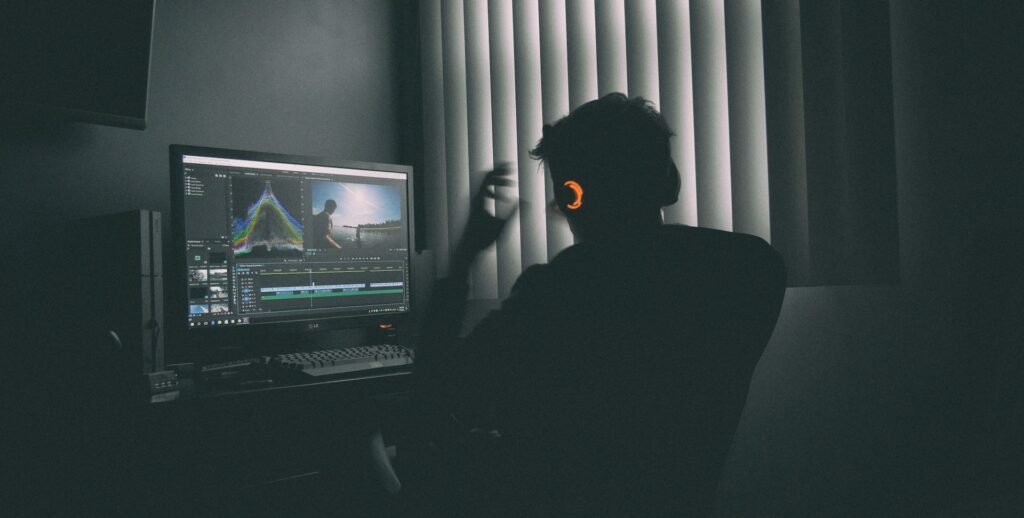 Video editor with headphones working on an edit in a studio